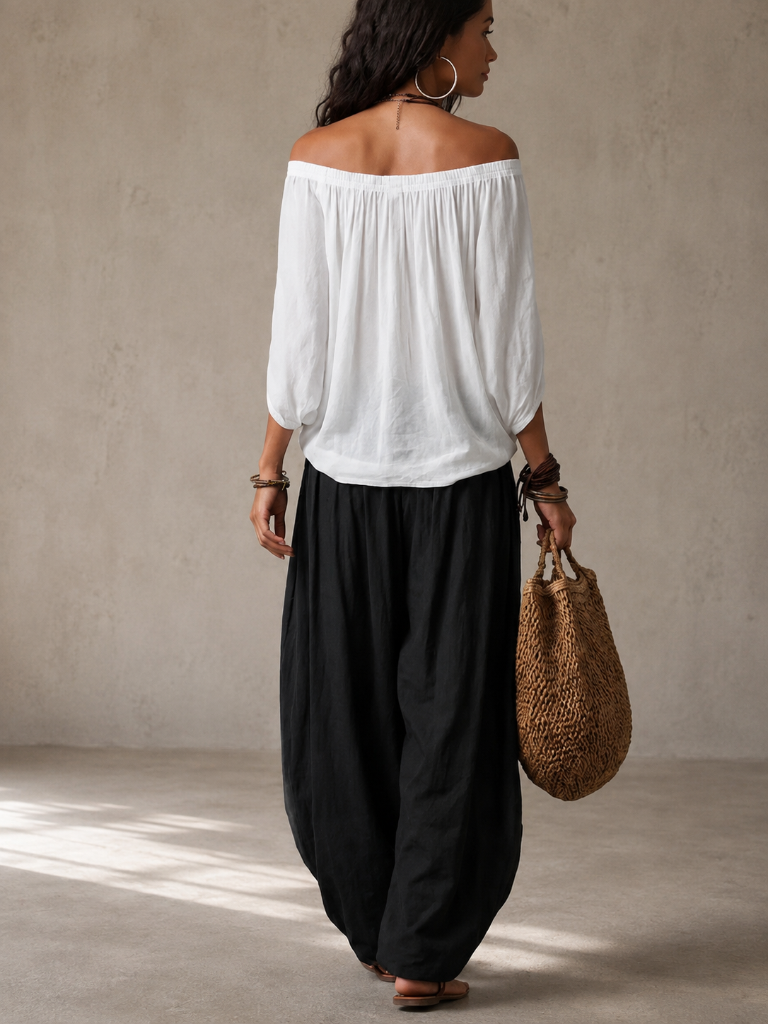 Conjunto BIANCA visto por detrás: blusa blanca off-shoulder y falda negra amplia