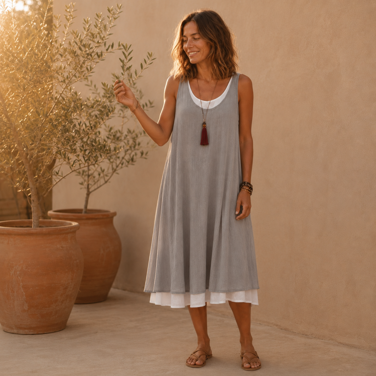 Vestido de tirantes gris con escote blanco y bajo ablusado sobre capa blanca