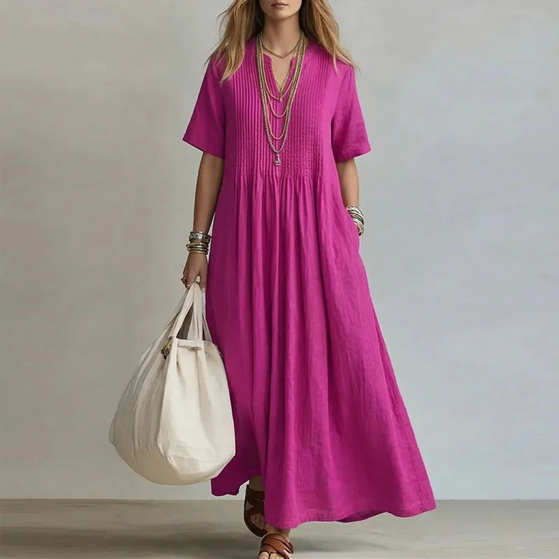 Vestido largo fucsia con manga corta y fruncido en el pecho, caída amplia