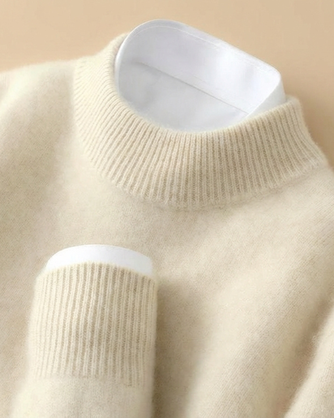 Jersey de punto beige de cuello alto con canalé y ribete blanco en el interior.
