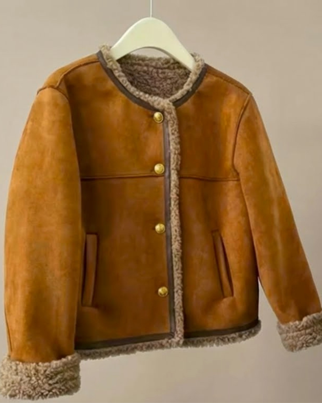Chaqueta ante camel con dobladillo de borreguillo y botones dorados, colgada en percha