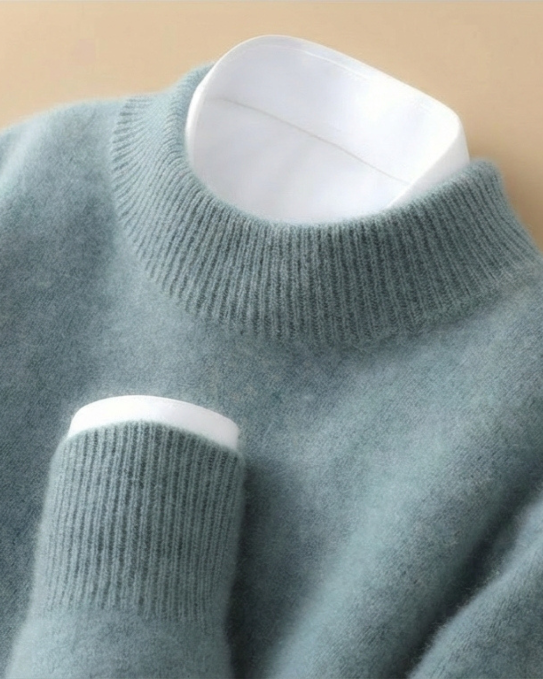 Jersey de punto azul turquesa con cuello alto de canalé y puño blanco a contraste.